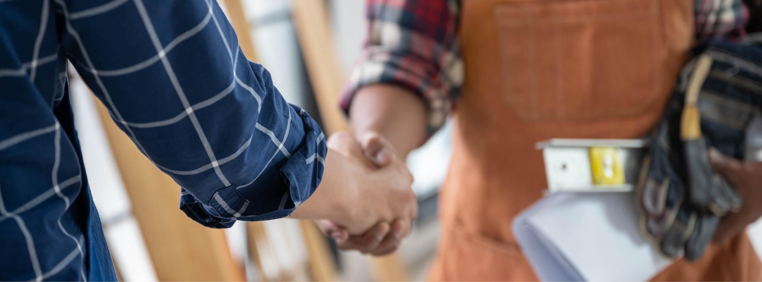 Ausbilder und schüttelt Auszubildendem die Hand