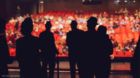 Das Bild zeigt Menschen auf einer Bühne