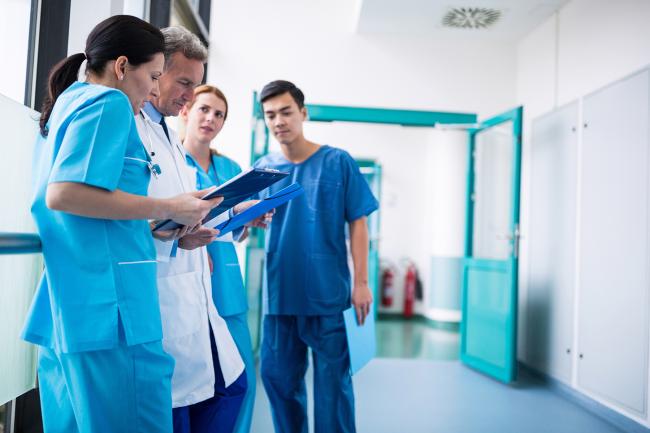 Ärztinnen und Ärzte bei einer Besprechung auf einem Flur im Krankenhaus