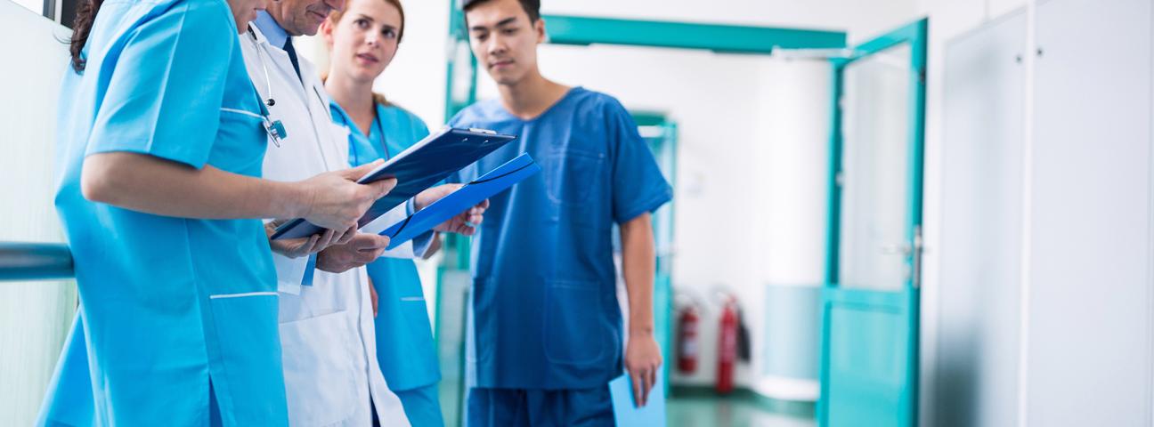 Ärztinnen und Ärzte bei einer Besprechung auf einem Flur im Krankenhaus