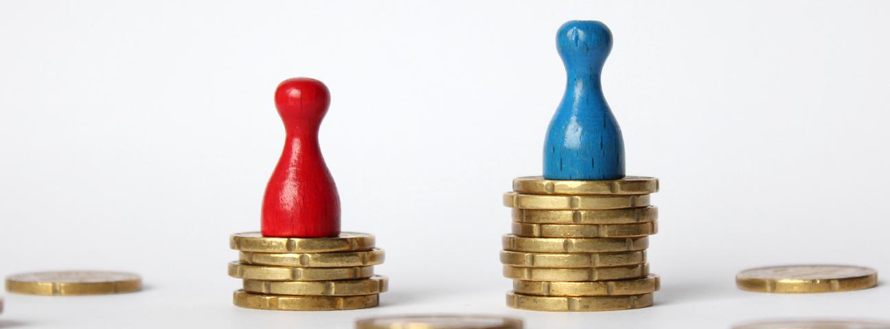 zwei Spielfiguren auf zwei Münzstapeln