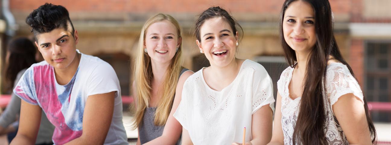 Gruppe von Schülerinnen und Schülern im Teenageralter auf dem Schulhof