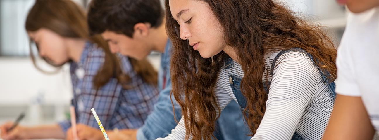 Das Bild zeigt Schülerinnen und Schüler, die eine Klasur schreiben. 