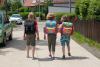 Drei Kinder mit Schulranzen sind auf dem Schulweg.